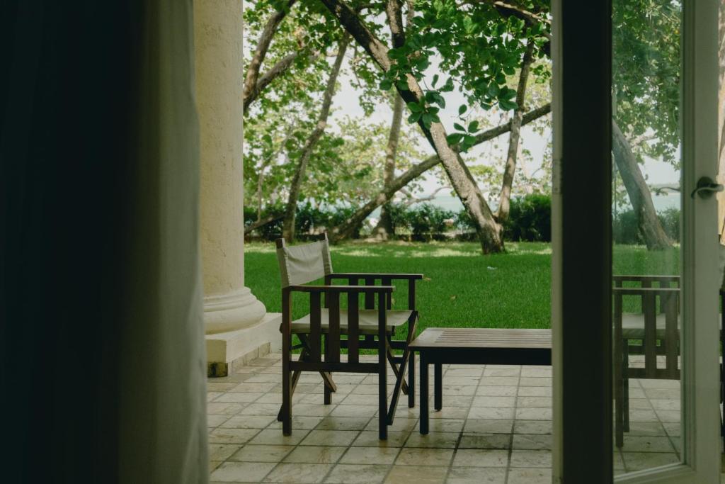 a patio with a table and chairs in the grass at Casa Colonial Beach & Spa in San Felipe de Puerto Plata