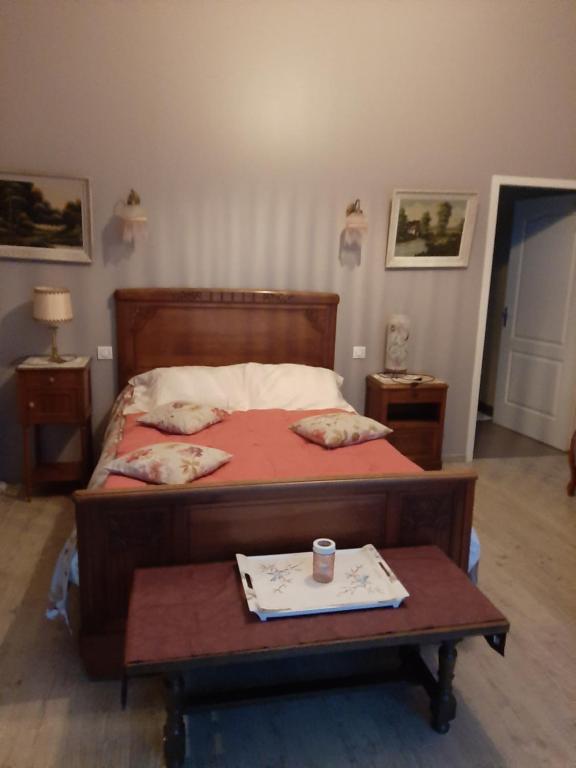 een slaapkamer met een bed en een tafel met een kopje erop bij chambre d hotes in Saint-Laurent-de-la-Barrière