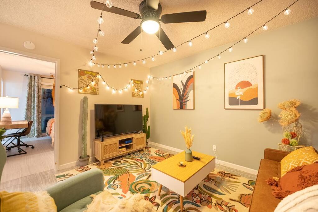 a living room with a ceiling fan and a tv at Seaside Romantic Escape Steps to Beach in Oceanside