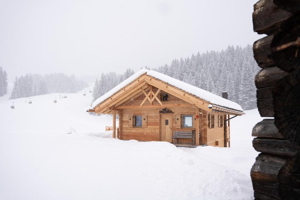 Cabaña de madera con nieve en el techo en Chalet Silvesterhütte, en Seiser Alm