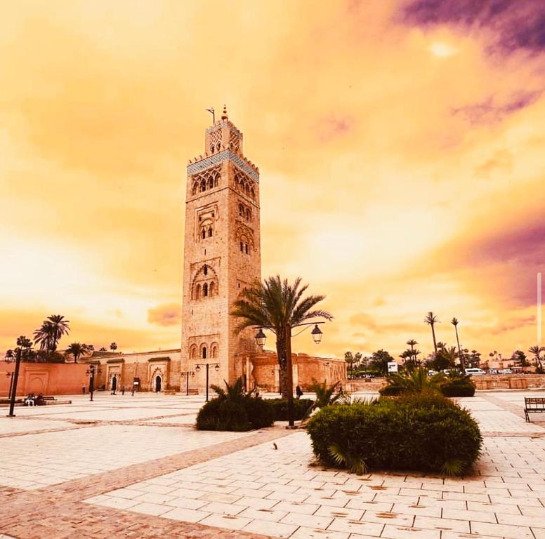 einen hohen Uhrturm vor einem Gebäude in der Unterkunft Riad Allal in Marrakesch