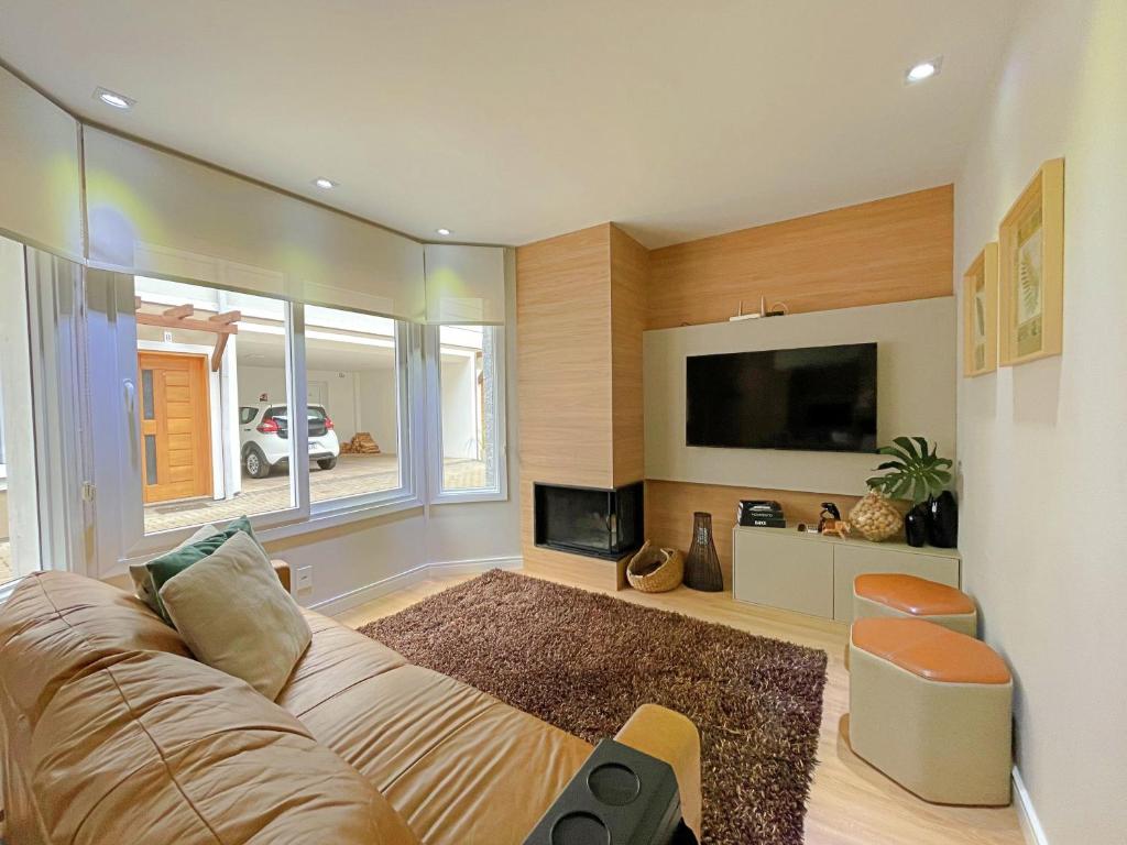 ein Wohnzimmer mit Couch und Flachbildfernseher in der Unterkunft Casa Encantos de Canela - Refúgio da família in Canela