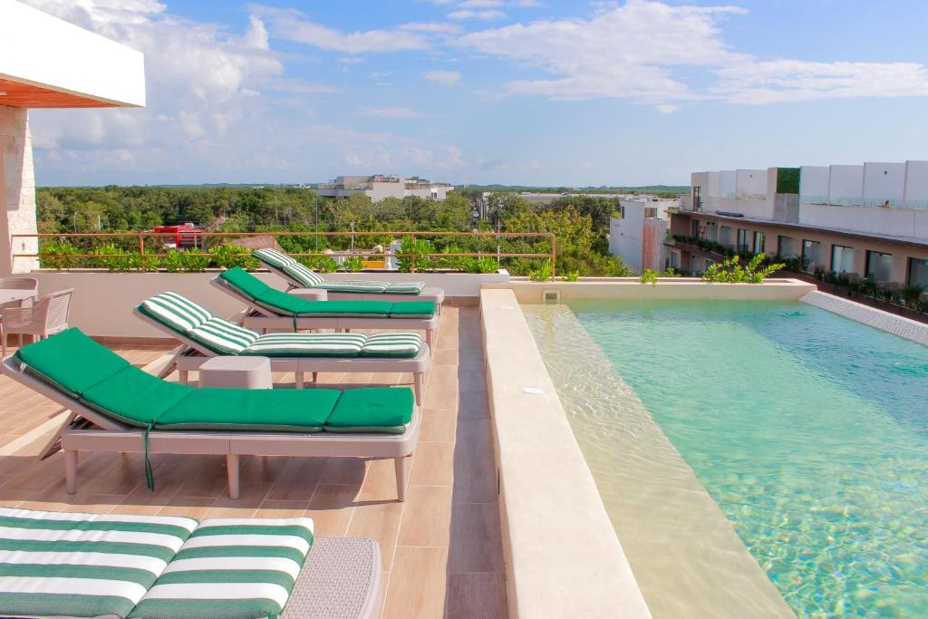 a swimming pool with chaise lounges and a swimming pool at Gama 09 Apartments in Tulum