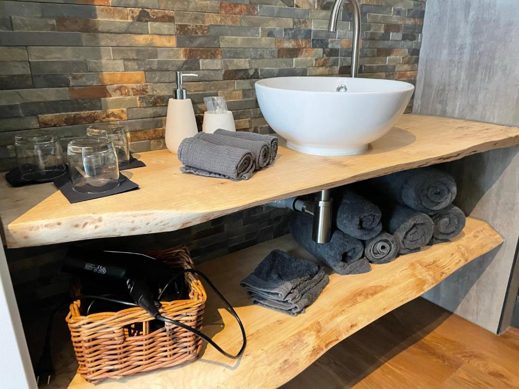 a bathroom sink on a wooden shelf with towels at Be-B in Wageningen