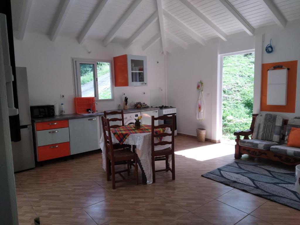 eine Küche mit einem Tisch und Stühlen im Zimmer in der Unterkunft Le papillon bleu in Sainte-Anne