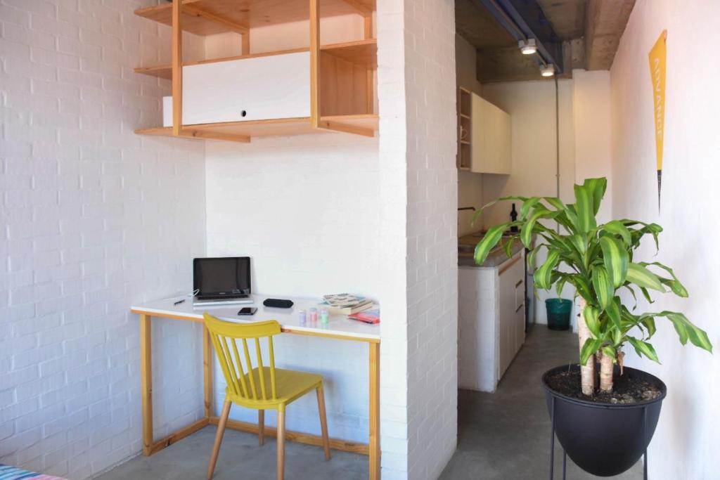 escritorio con silla amarilla en una habitación en Indie Studio, en Medellín