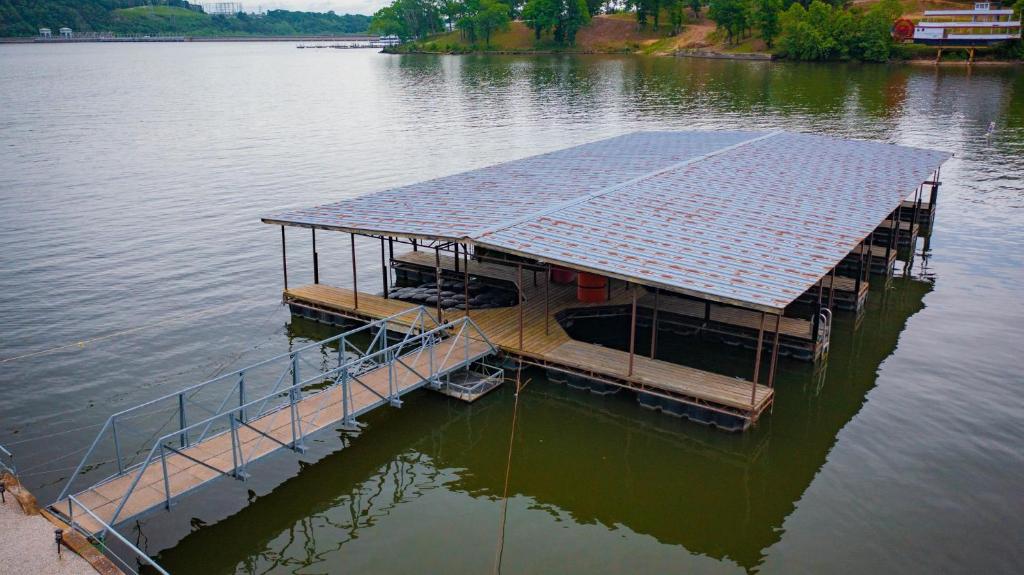 a floating dock with a solar roof on the water at Lakeshore Fishing Cabin #12 , dock/boat slip/ramp on location in Lake Ozark