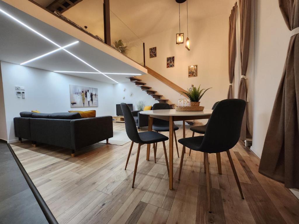 een woonkamer met een tafel en stoelen en een bank bij K21 "The Good Shepherd" Apartment in Boedapest