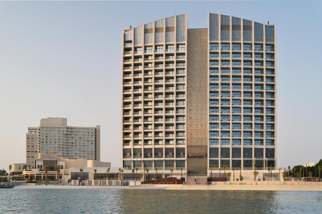 un gran edificio junto a una masa de agua en InterContinental Residences Abu Dhabi, an IHG Hotel en Abu Dabi