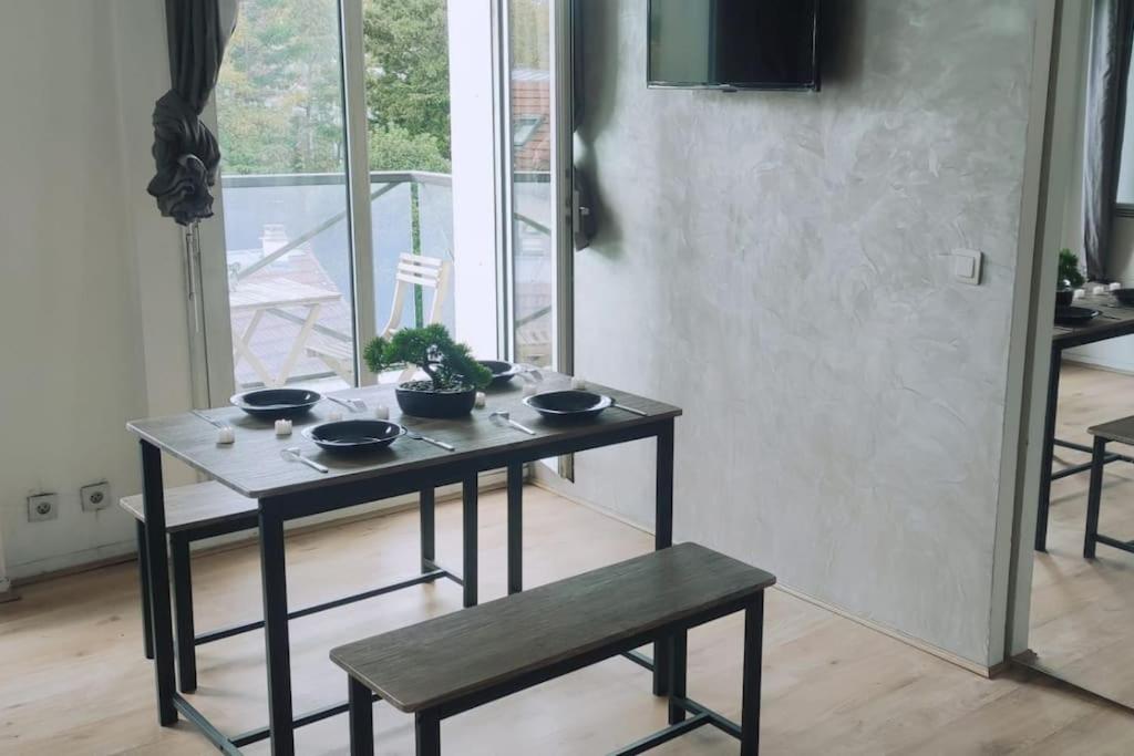 - une table avec des bols dans le salon dans l'établissement à 7 min de Paris, 2 pièces 