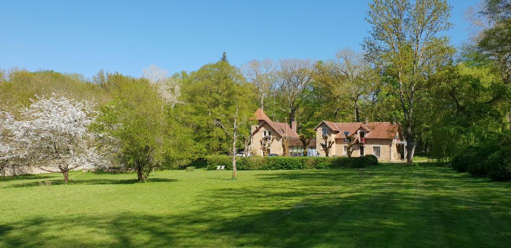 une maison dans un champ d'herbe verte dans l'établissement Gîte dans un Domaine Historique, à Chevreuse