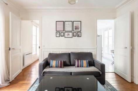 a living room with a couch and a laptop in it at SUITE ELISE Passy in Paris