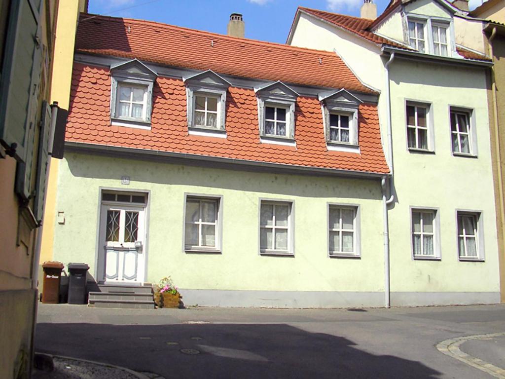 ein weißes Haus mit orangefarbenem Dach in der Unterkunft Ferienwohnung Alte Stadtmauer in Bamberg