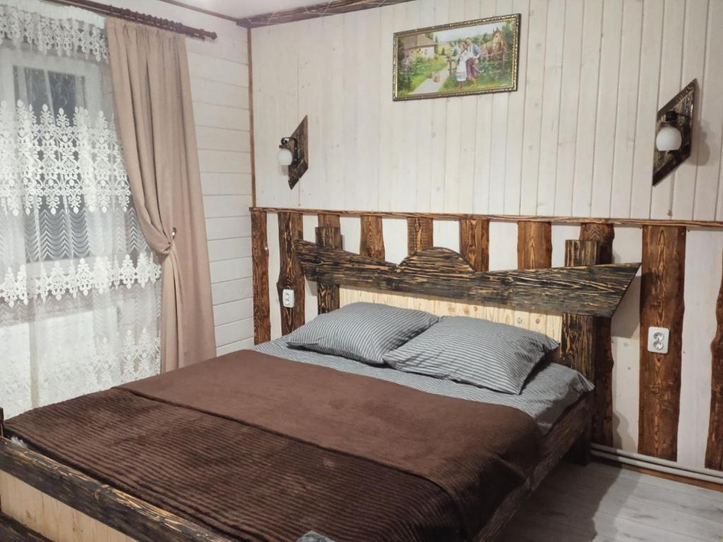 a bedroom with a wooden bed and a window at Кольорові подорожі 2 in Slavske