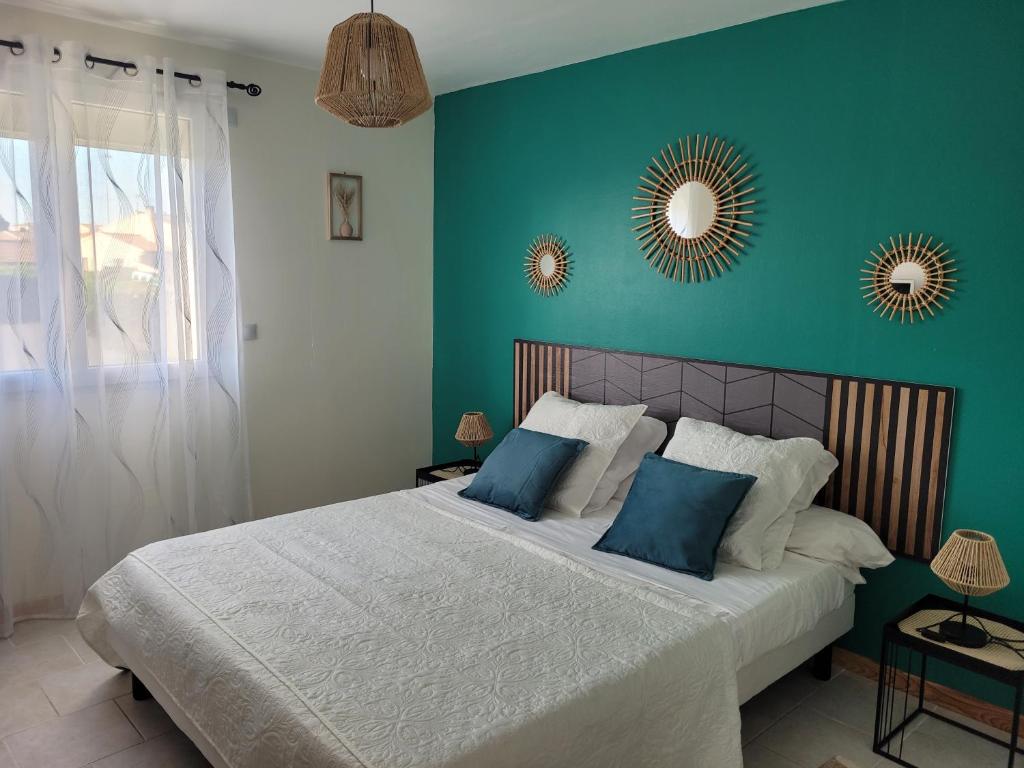 a bedroom with a large bed with blue walls at Appartement agréable et spacieux ensoleillé in Valros