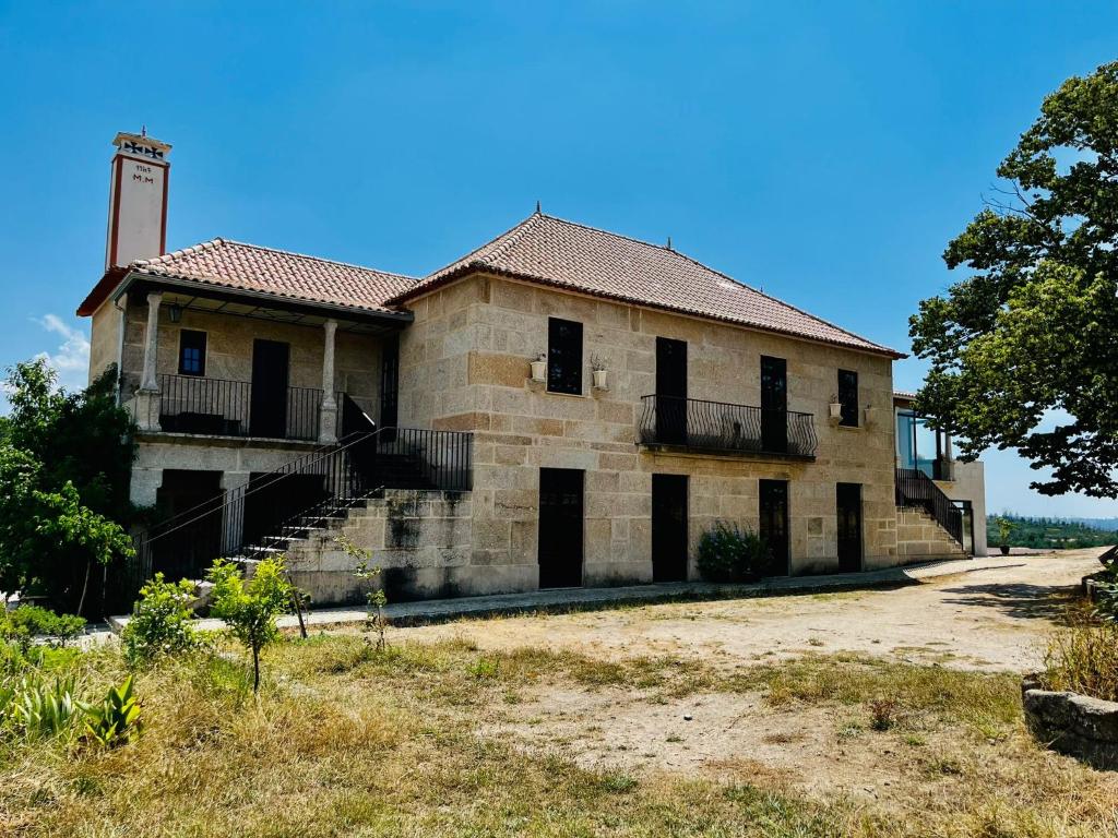 ein altes Backsteingebäude mit einem Turm auf der Spitze in der Unterkunft Quinta da Lua Nova in Travancinha