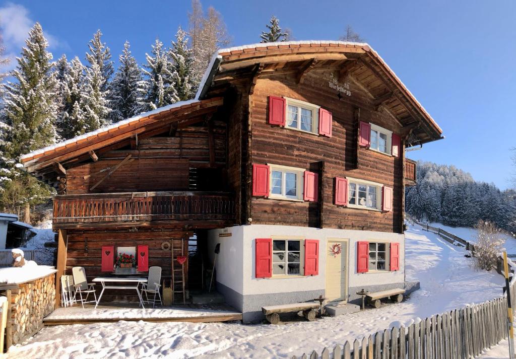 a log cabin in the snow with a table at Sonniges Chalet Arosa für 6 Pers alleinstehend mit traumhaftem Bergpanorama in Langwies