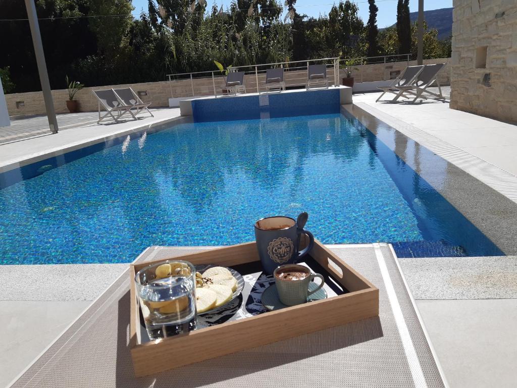 a tray of food sitting next to a swimming pool at Matala Prime Villas in Matala