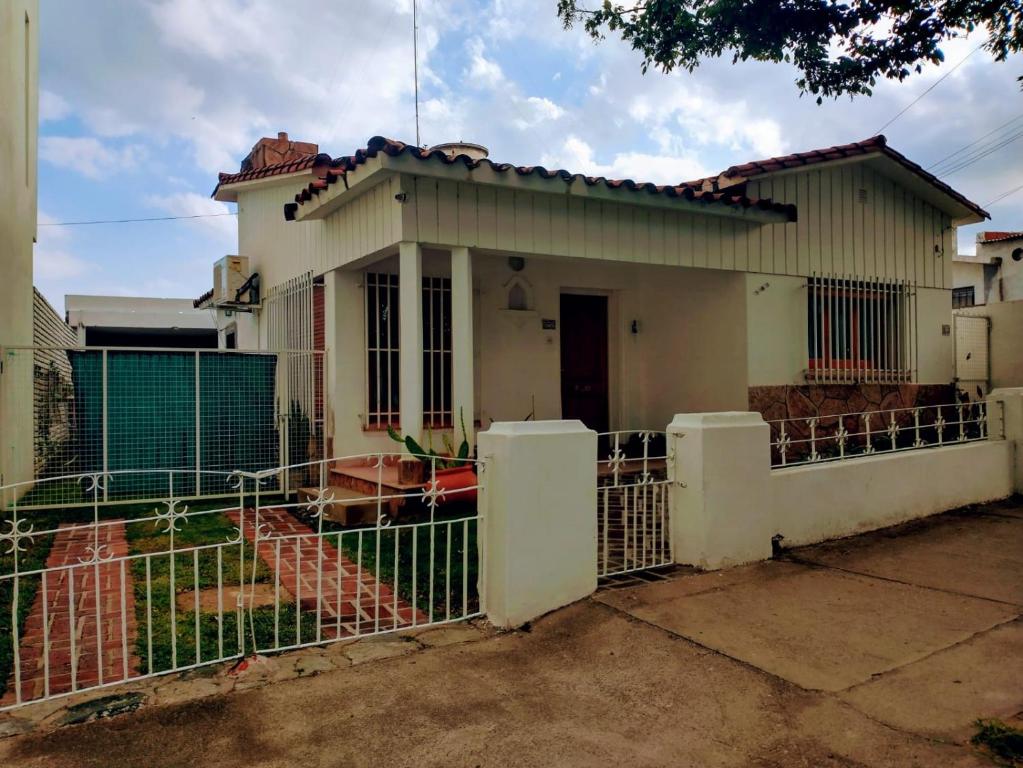 une maison avec une clôture devant elle dans l'établissement Casa Olivia, à Alta Gracia