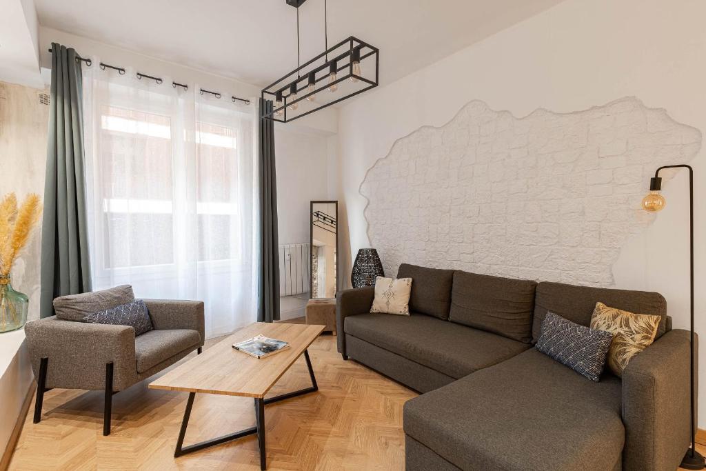 - un salon avec un canapé, des chaises et un mur en briques dans l'établissement Decorated 2 bedrooms AIR CONDITIONNING, city center, à Nice