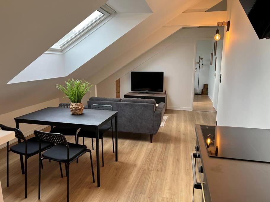uma sala de estar com uma mesa e um sofá em Appartement T3 cœur de Dinan em Dinan