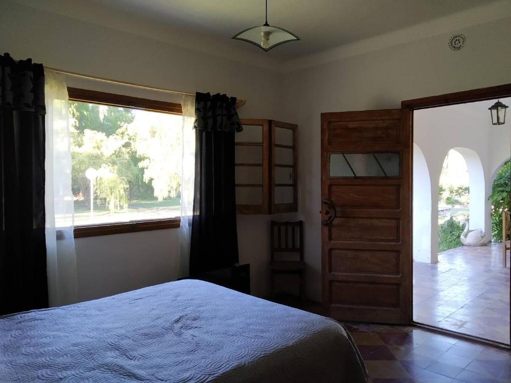 1 dormitorio con cama y ventana grande en Finca La Codiciada en San Rafael