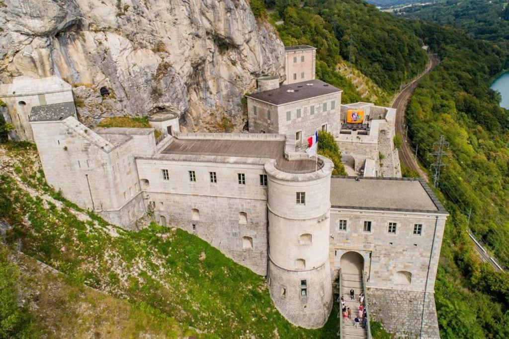 an old castle on a hill with a mountain at Proche gare, cosy, courte et moyenne durée in Bellegarde-sur-Valserine