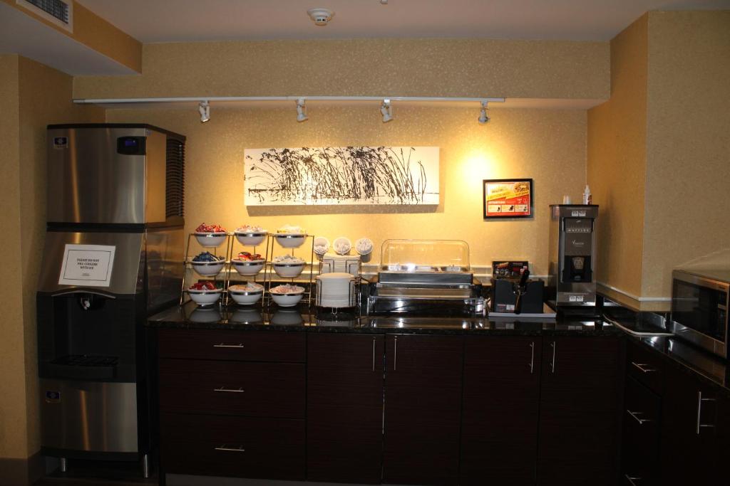 a kitchen with a counter with bowls and a refrigerator at Sleep Inn in Bend