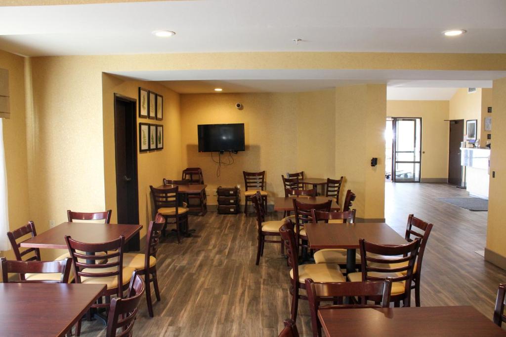 a restaurant with tables and chairs and a flat screen tv at Sleep Inn in Bend