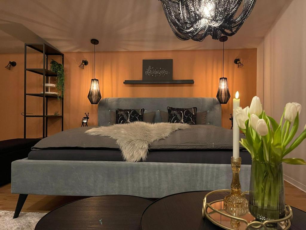 um quarto com uma cama com uma colcha cinzenta e uma mesa em Stay at Smilla - Boutique Apartments mit Küche - Parken - Klima - Netflix - Waschmaschine em Wiesbaden