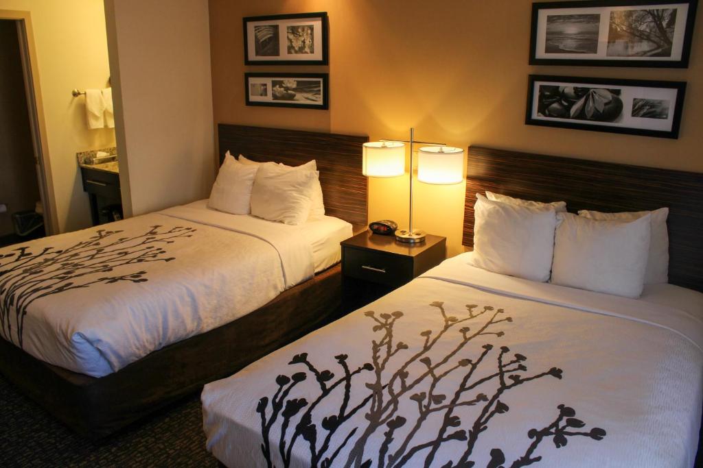 a hotel room with two beds and two lamps at Sleep Inn in Bend