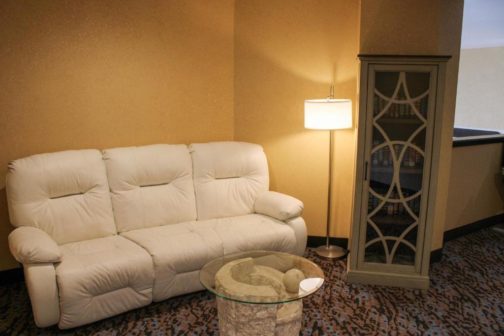 a living room with a white couch and a table at Sleep Inn in Bend