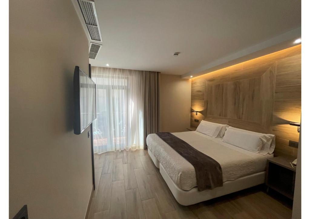 Habitación de hotel con cama y ventana en Castilla Guerrero en Málaga
