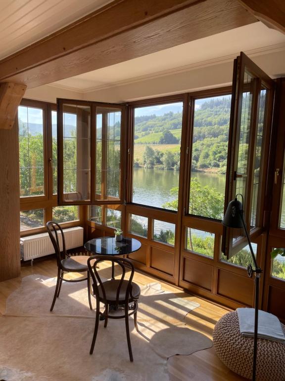 um quarto com uma mesa e cadeiras e vista para um rio em Boutique Guesthouse Das WOHLGEMUTH HEIM Mosel Weingut em Zell an der Mosel