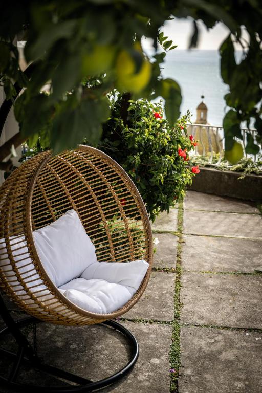 a wicker chair with a pillow sitting on a patio at Villa Dalu in Positano