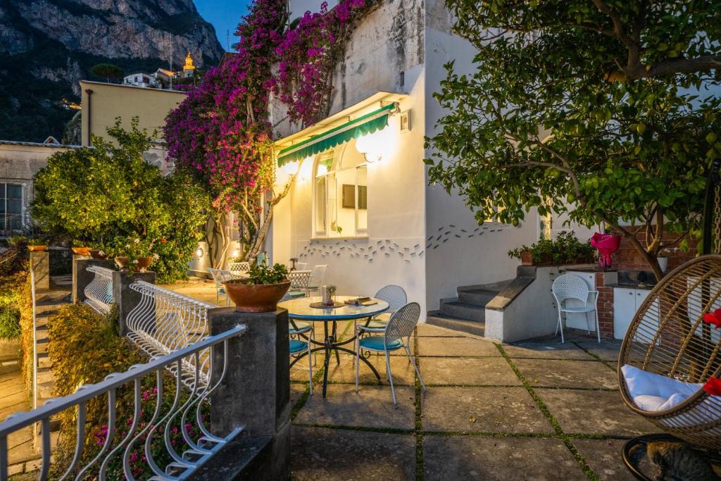 a patio with a table and chairs and flowers at Villa Dalu in Positano