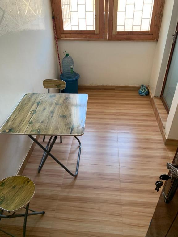 a table and chairs in a room with wooden floors at Studio meublé aux Mamelles in Dakar