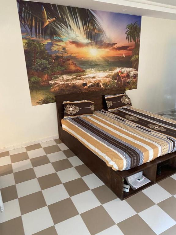 1 cama en una habitación con un cuadro en la pared en Studio meublé 1 à ouakam Comico Dakar, en Dakar