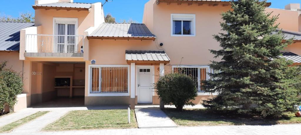 a house with a tree in front of it at AMANECER in Las Grutas