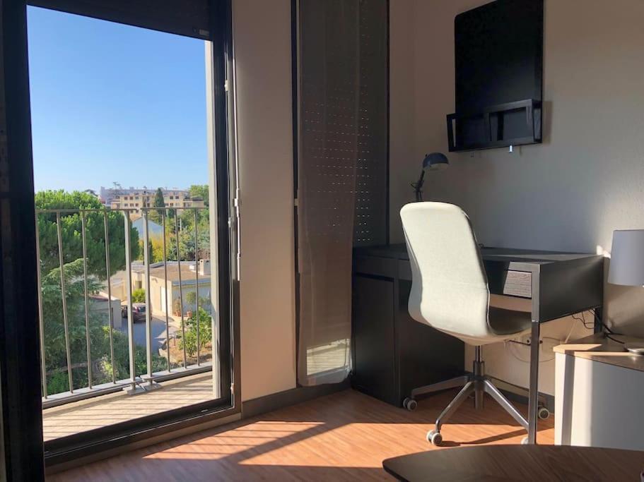 a room with a desk and a chair and a window at Studio - Centre Ville - free parking in Montpellier