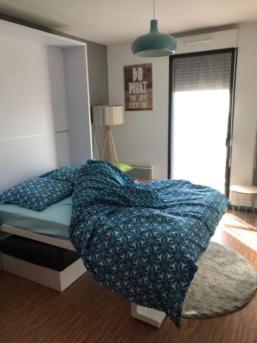 a bedroom with a bed with a blue blanket on it at Studio - Centre Ville - free parking in Montpellier