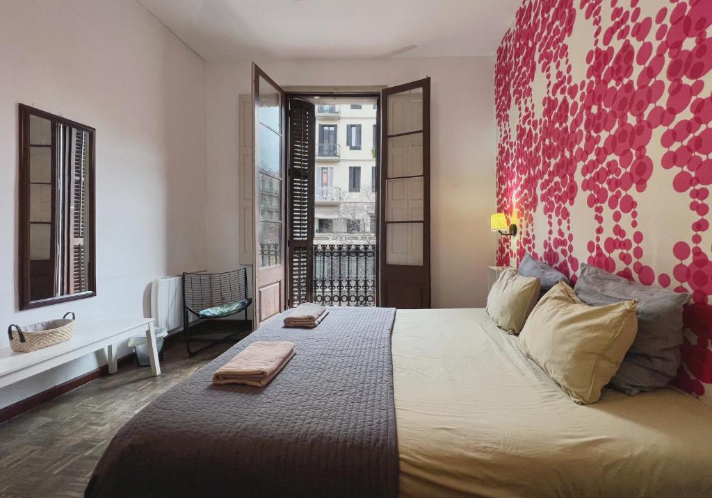 a bedroom with a large bed with a red wall at Lolita BCN Apartment en el Eixample in Barcelona