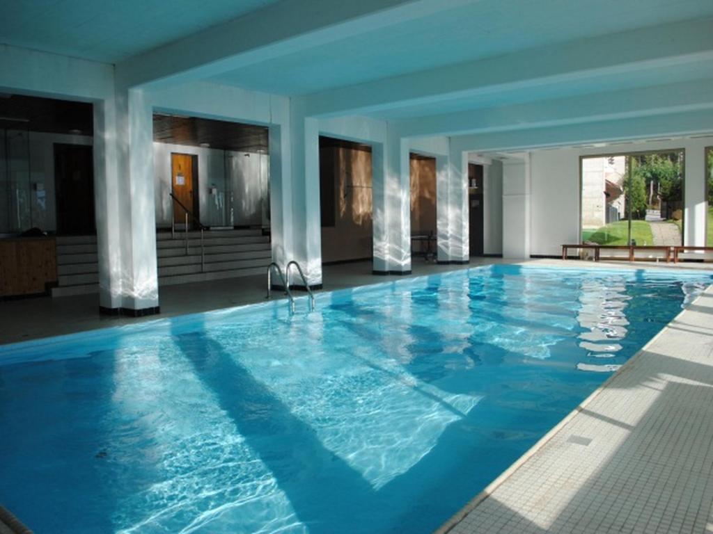 a large pool with blue water in a building at Residence Cransalpin in Crans-Montana