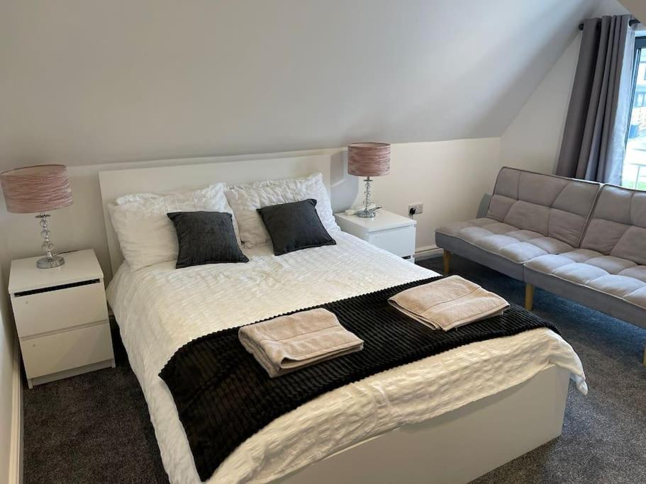 ein Schlafzimmer mit einem großen Bett und einem Sofa in der Unterkunft Rosey Lodge - One Bed Cousy Flat - Parking, Netflix, WIFI - Close to Blenheim Palace & Oxford - F5 in Kidlington