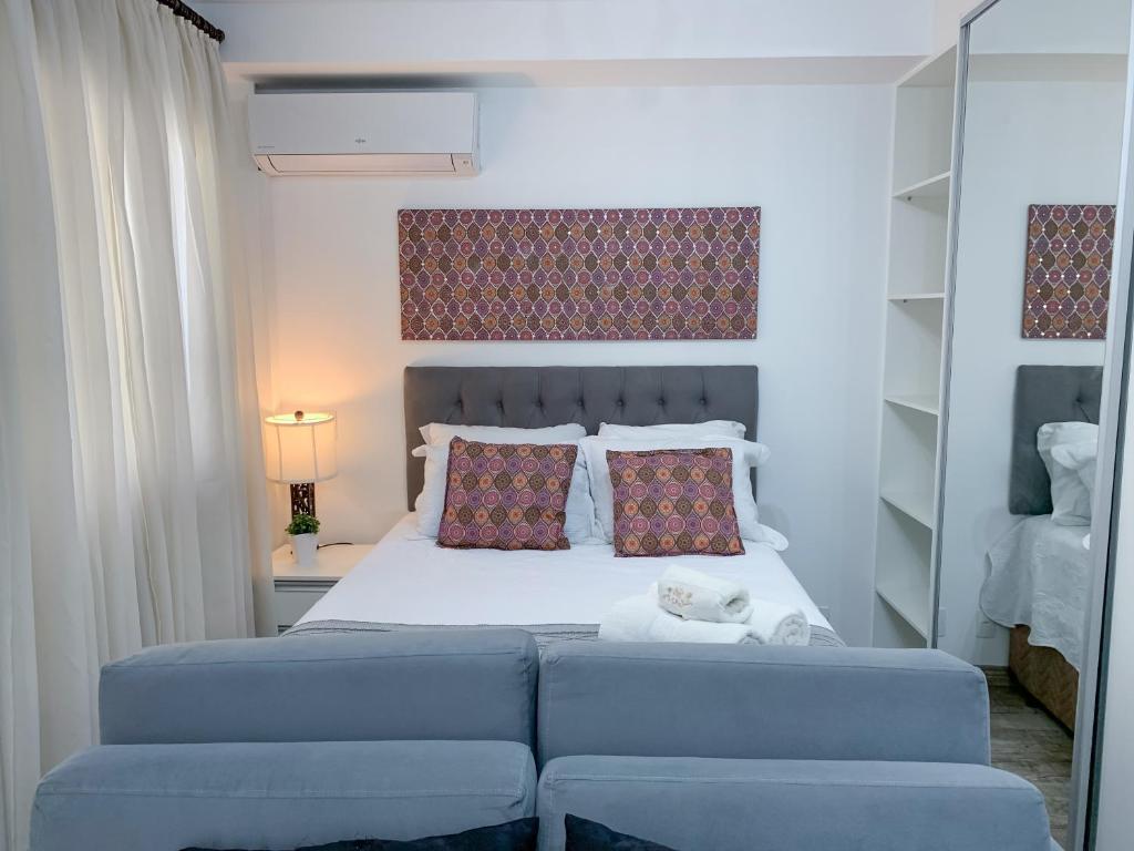 1 dormitorio con 1 cama y 1 sofá azul en Loft Lotus 5 - Lindo Studio na Liberdade, en São Paulo