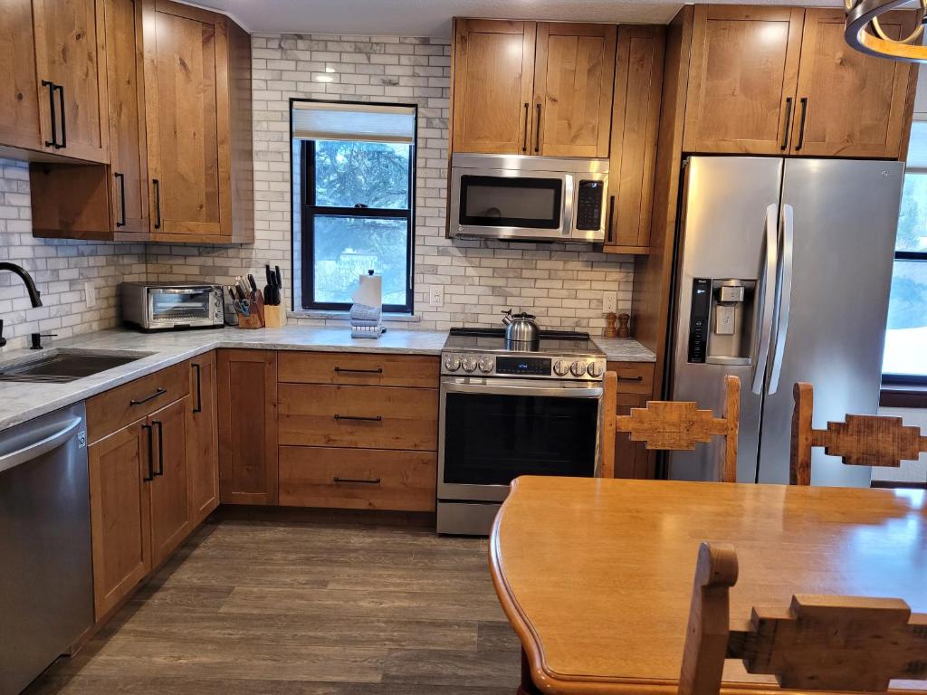 une cuisine avec des placards en bois et des appareils en acier inoxydable dans l'établissement Mountainside D177, à Frisco
