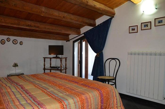 1 dormitorio con 1 cama, TV y ventana en Bed & Breakfast Hostel H24, en Ragusa