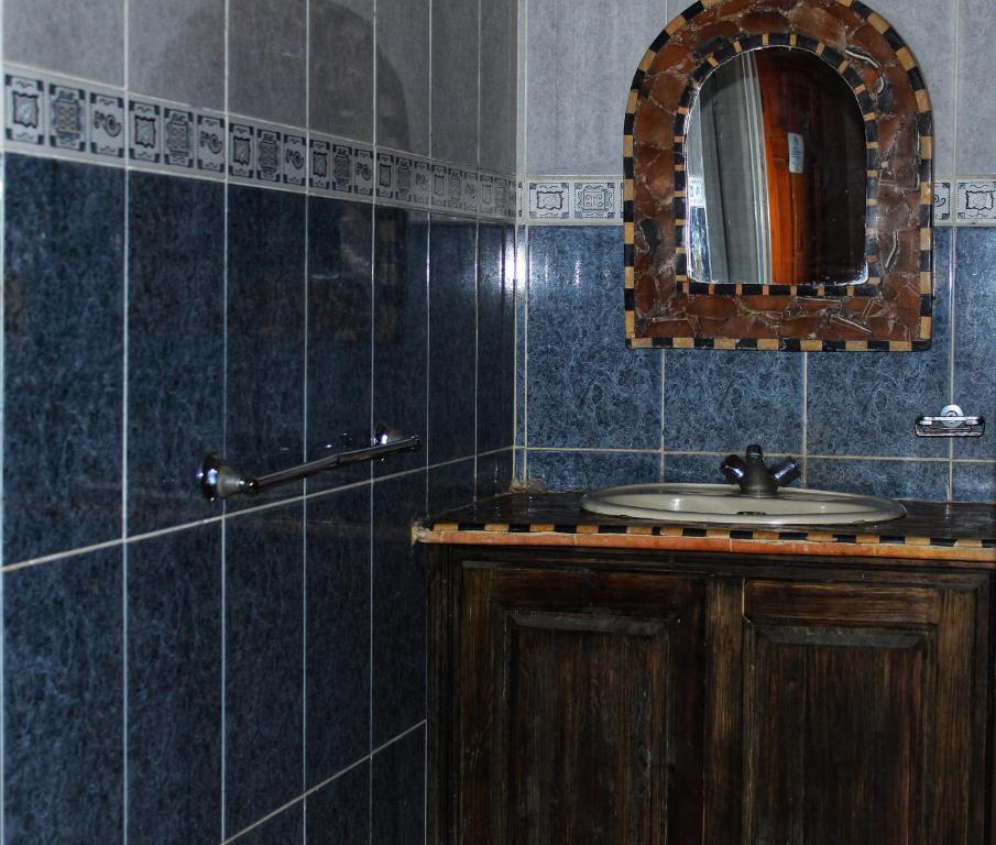 een badkamer met een wastafel en een spiegel bij Appartement Afgo Ouarzazate in Ouarzazate
