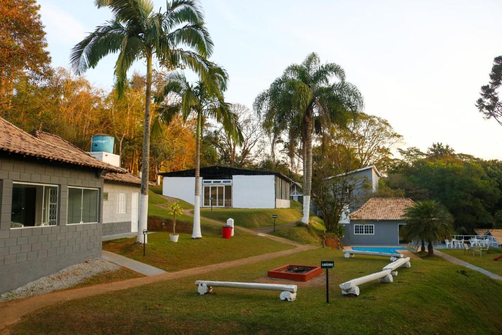 un patio con un parque infantil con una casa y palmeras en Chácara Misfav capacidade de 200 pessoas, en Mogi das Cruzes