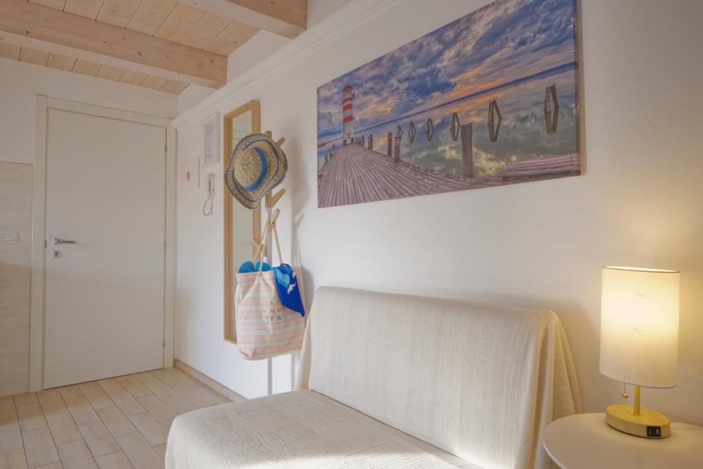 a bedroom with a bed and a painting on the wall at Porto d'aMare - Rooms in Porto Recanati